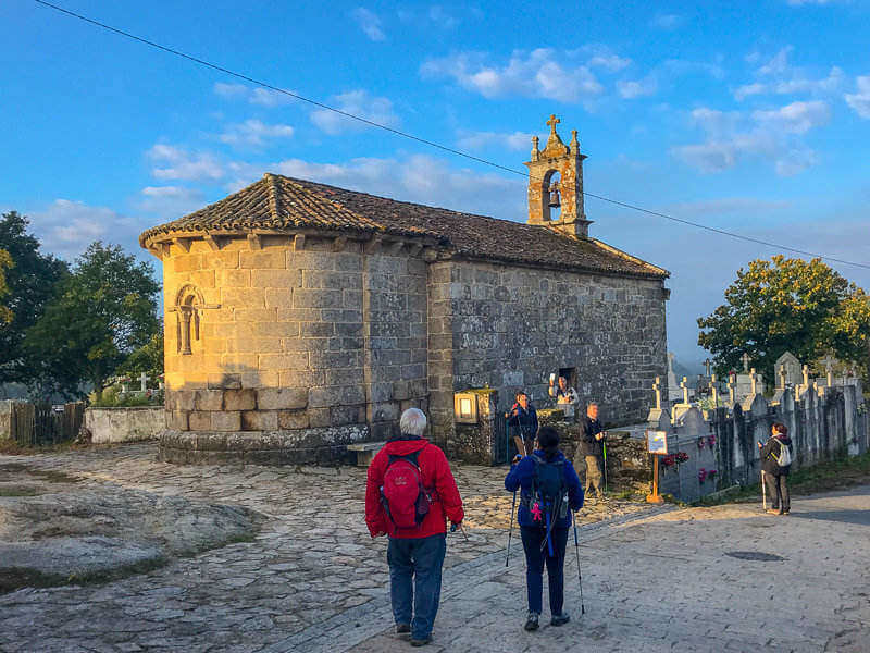 Pilgrims looking at a church on the Camino de Santiago, the last 100 km
