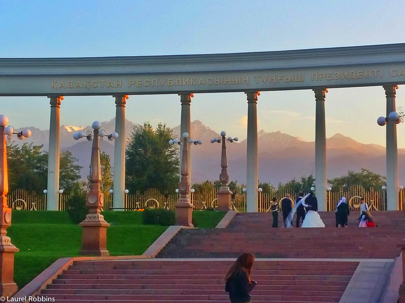 First Presiden'ts Park in Almaty Kazakhstan. Shown is a bride and groom getting their wedding photos done with the Tien Shan mountains as the backdrop.