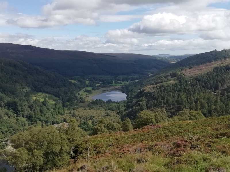 Hikers pass Guinness Lake, Lough Tay in the Wicklow Mountains