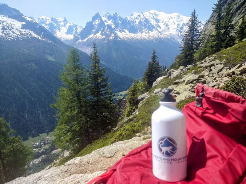 view of Mont Blanc from the Grand Balcon Sud w/ a red backpack and Monkeys and Mountains waterbottle