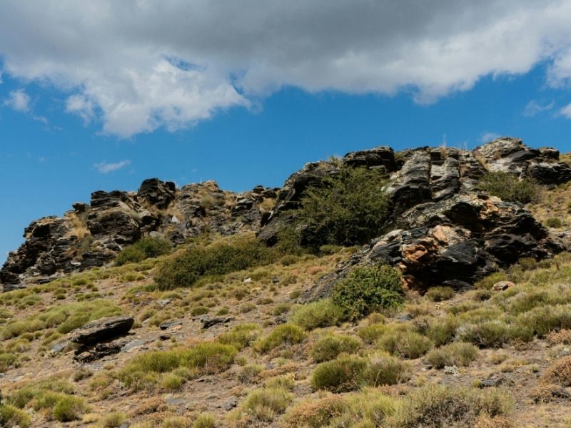 A rocky outcrop on a grassy ridge on the hiking trails of the Alpujarras in southern Spain