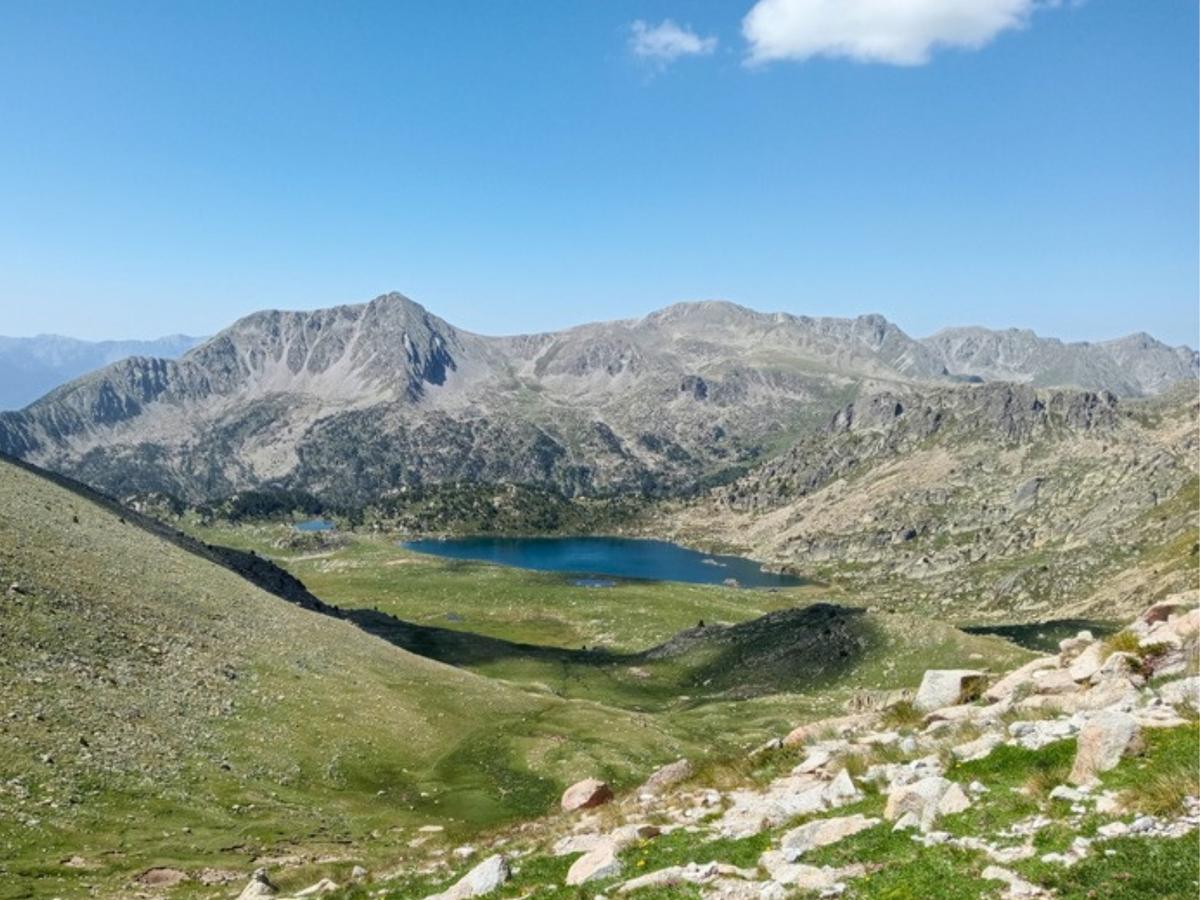 A glacial lake in a rocky cirque below the peaks on an Andorra hiking tour in the Pyrenees