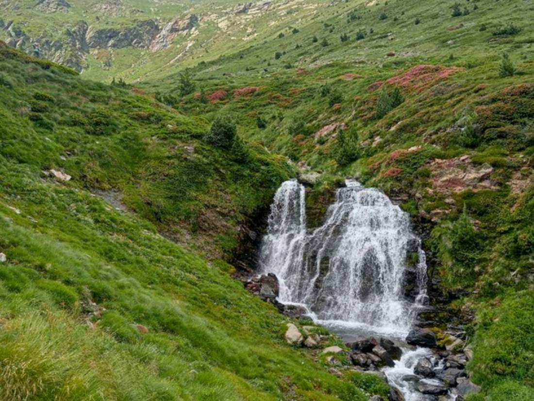 A waterfall in a green mountain valley on the Andorra hiking routes of our tour