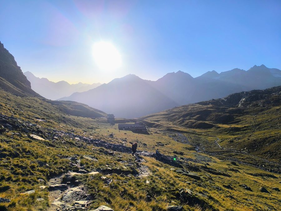 Hiker on the trail at sunrise in Gran Paradiso National Park, Italian Alps