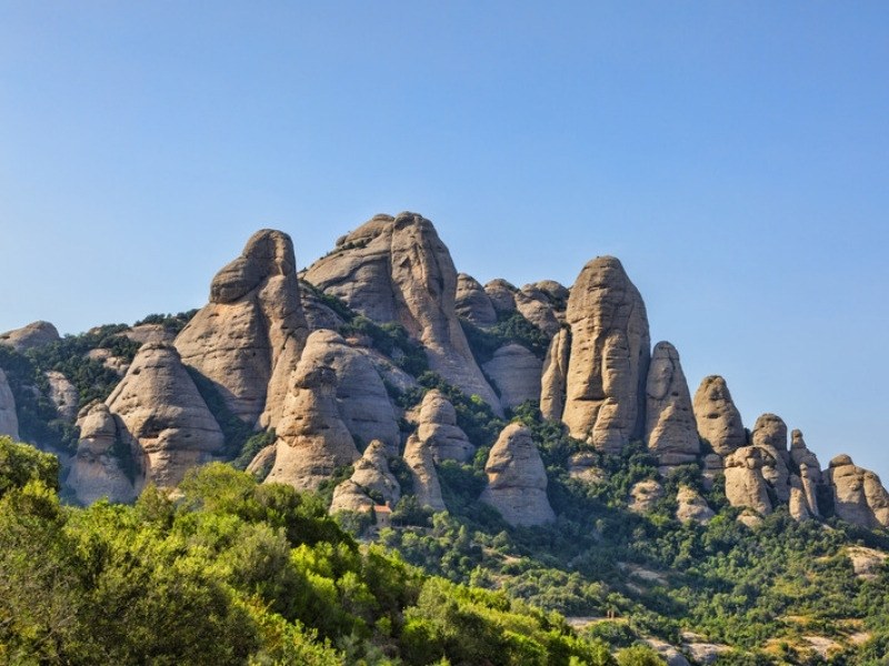 The weathered rock pinnacles of Montserrat above the forest in Catalonia