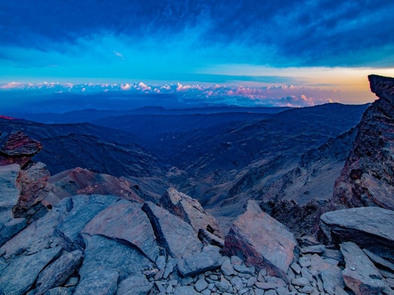 Sunrise from the rocky summit of Mulhacen, the highest peak in mainland Spain, looking down over the ridges of the Sierra Nevada