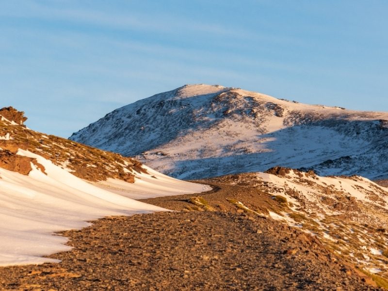 Golden evening light on a snow-covered summit in the high Sierra Nevada above the Alpujarras