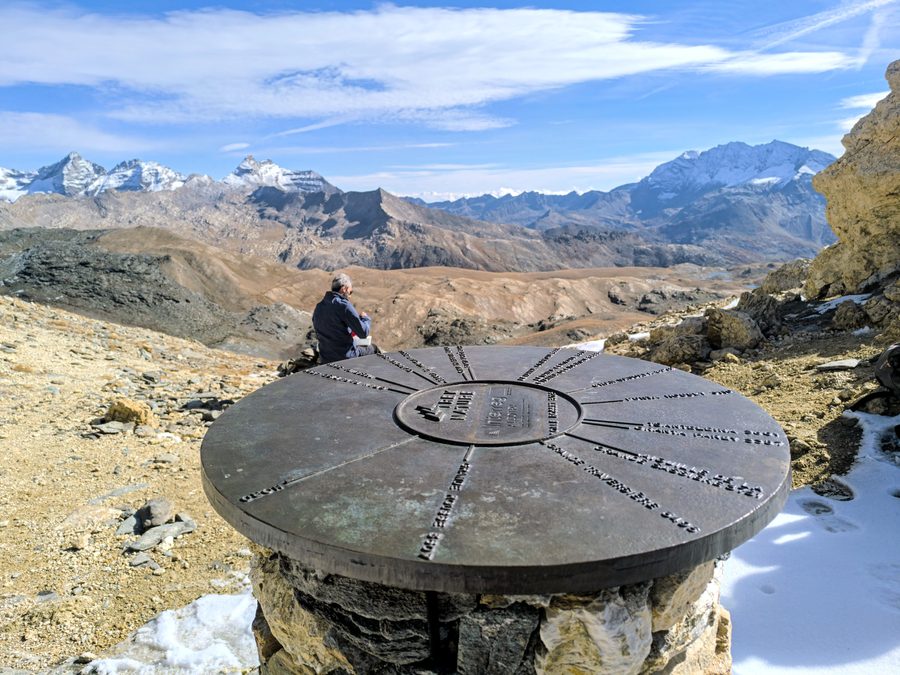 The stone orientation table at the Col Rosset viewpoint, looking out over the peaks of the Italian Alps