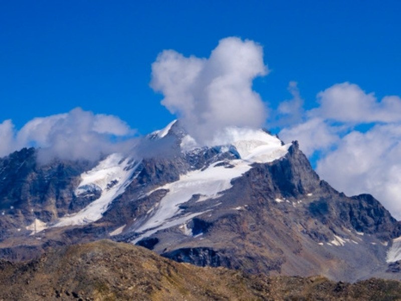 A glaciated peak with cloud above the ridge in Gran Paradiso National Park, Italian Alps