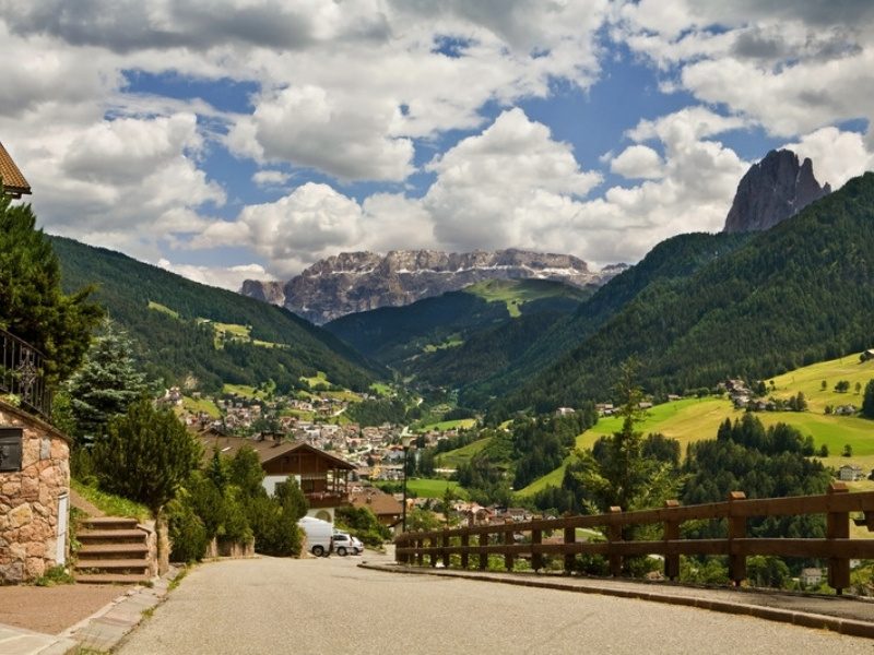 A quiet road through Val Gardena toward Sassolungo, near the hotels of Ortisei, Dolomites, Italy
