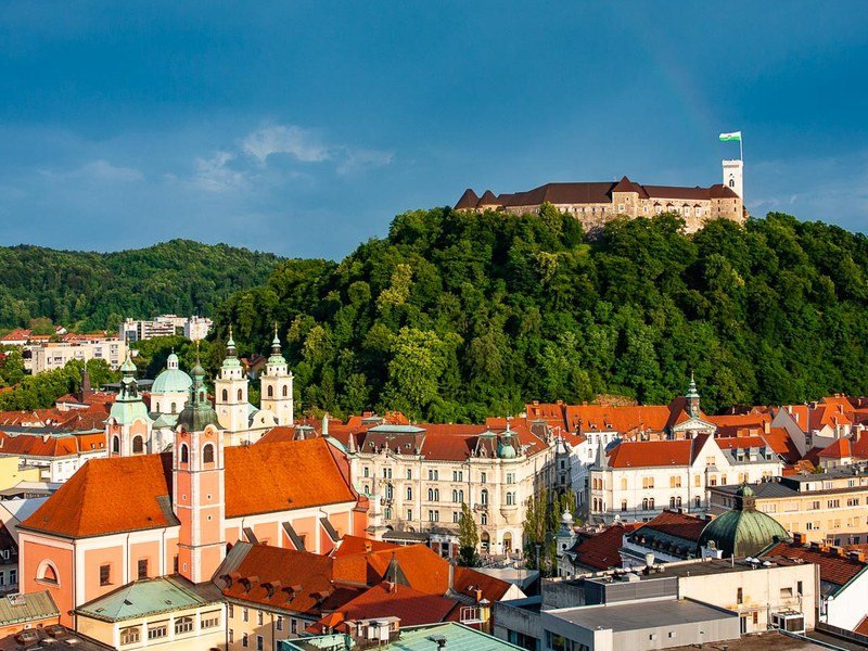 Ljubljana castle on its wooded hill above the red roofs and church towers of the old town, the start of the Slovenia hut to hut hiking tour