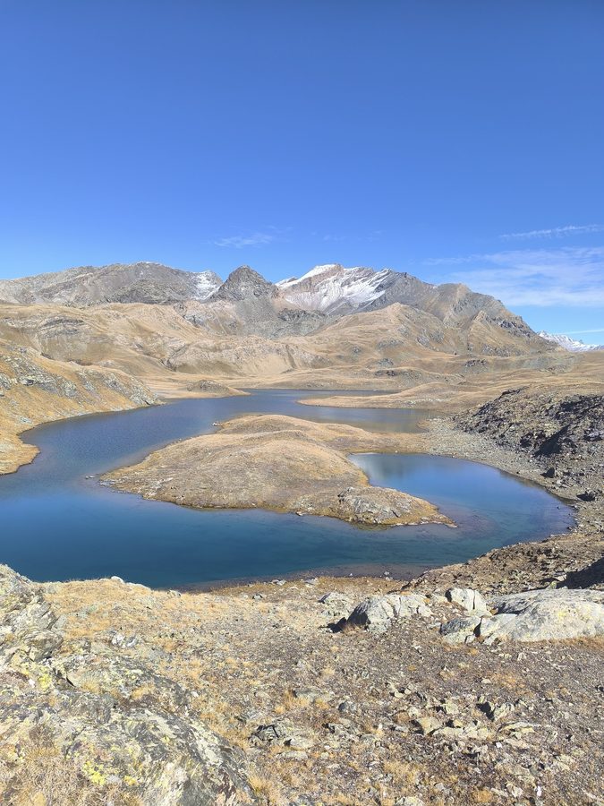Twin blue lakes on the Plan del Nivolet below the snow-capped peaks of Gran Paradiso National Park