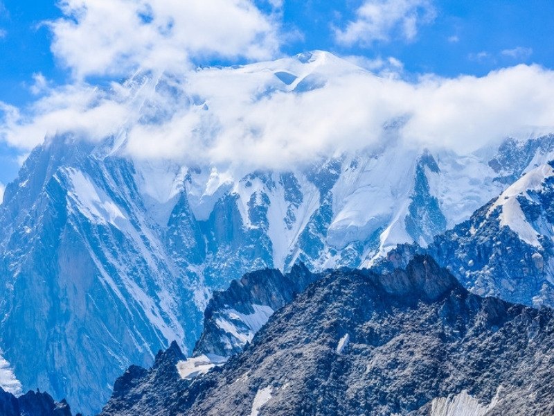 The Italian side of Mont Blanc above Courmayeur in the Aosta Valley, with dark rock ridges below the snow